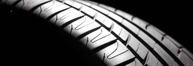 A close up of a car tire on a black background.